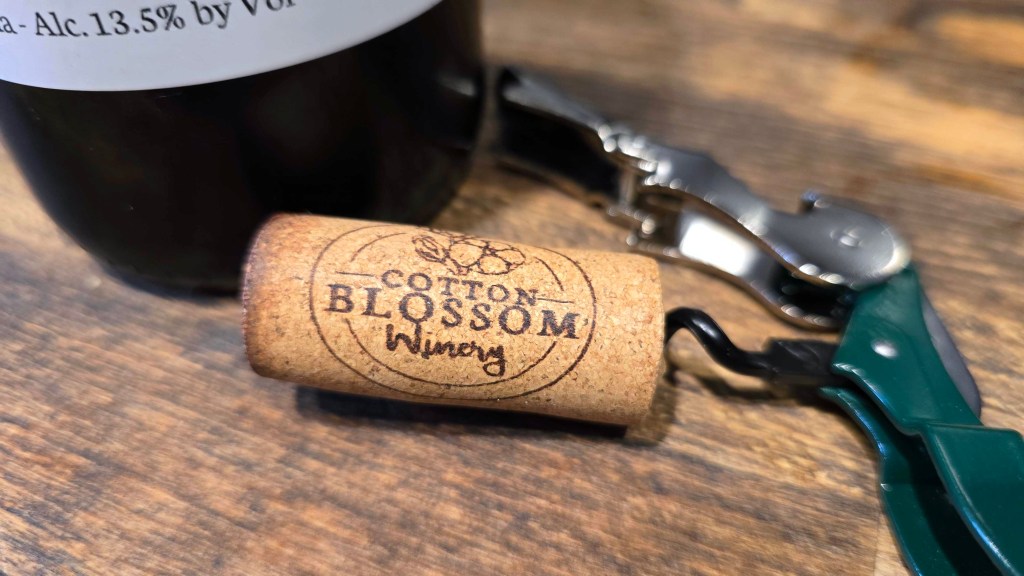 Wine cork with the "Cotton Blossom Winery" logo printed on it.